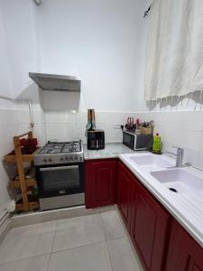a kitchen with red cabinets and a stove and a sink at Casa Shala in Tunis