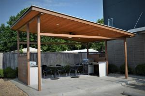 a pergola with chairs and a grill in a backyard at Candlewood Suites - Muskogee by IHG in Muskogee