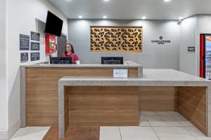a woman standing at a reception desk in a store at Candlewood Suites - Muskogee by IHG in Muskogee