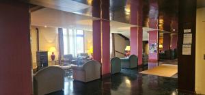 a lobby with couches and chairs in a building at Hotel Rey Sancho Ramírez in Barbastro