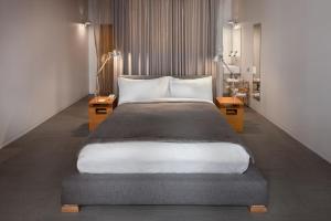 a bedroom with a large bed and two tables at Hotel Gault in Montreal +67 photos