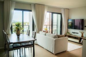a living room with a white couch and a table at Comfortable 2Bdr Bangtao Space Condo in Ban Thalat Choeng Thale