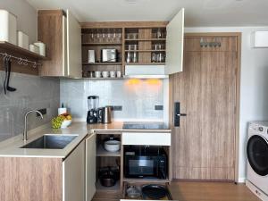 a kitchen with a sink and a microwave at Comfortable 2Bdr Bangtao Space Condo in Ban Thalat Choeng Thale