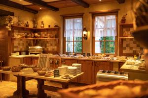 a large kitchen with a table and some windows at Hotel Amselgrundschlößchen in Kurort Rathen