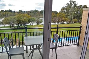 a balcony with a table and chairs and a view of a pool at 1009 Studio Apartment Pont de Val in Parys