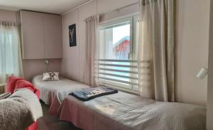 two beds in a room with a window at Einon Tupa in Kittilä
