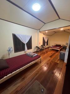 an empty room with a large bed and a table at Namosototie in Ranong