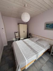 a bedroom with a large bed and a chandelier at Maison Ustou46 in Cahors