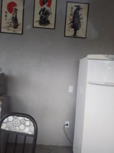 a kitchen with a refrigerator and pictures on the wall at hospedagem com passeio de quadriciclo in Guapimirim