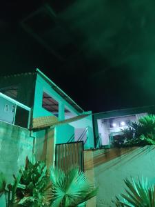 a house at night with green lights at hospedagem com passeio de quadriciclo in Guapimirim