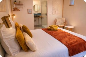 a bedroom with a large white bed with pillows at La Parenthèse, chambres d'hôtes in Rochegude