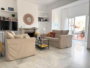 a living room with two couches and a fireplace at Holiday Home Sol de Estepona by Interhome in Estepona