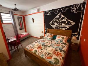 a bedroom with a bed and a desk and a table at Matilona in Sainte-Rose