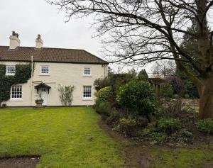 a white house with a yard in front of it at West Cottage, Free Breakfast supplied with free range eggs With log burner in Towton