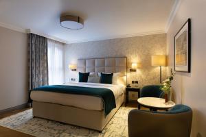 a hotel room with a bed and a chair at The Rathbone Hotel, Fitzrovia in London