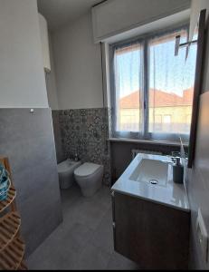a bathroom with a sink and a toilet and a window at Sweet home in Novara +8 photos