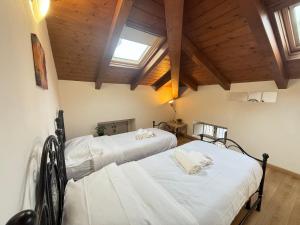 two beds in a room with wooden ceilings at Nuvola di Parma// del Ducato 1 in Parma