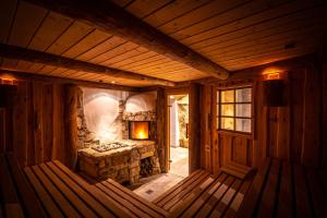 a room with a stone fireplace in a log cabin at Hotel Amselgrundschlößchen in Kurort Rathen
