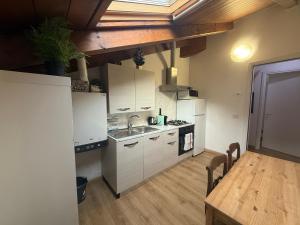 a kitchen with white cabinets and a wooden table at Nuvola di Parma// del Ducato 1 in Parma +16 photos