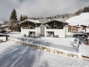 a house in the snow with snow covered ground at 21trees in Ellmau