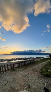a fence on the beach with the ocean in the background at Brezza Marina in Gallico