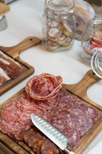 a cutting board with a piece of meat and a knife at Hotel Boutique Casa Romana Villa in Seville