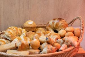 a basket filled with bread and pastries on a table at Hotel Boutique Casa Romana Villa in Seville