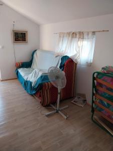 a small bedroom with a bed with a fan at Studio apartman u ruralnom okruženju in Donji Karin