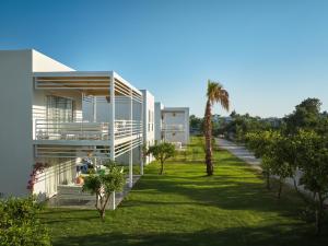 a house with a palm tree next to a yard at Flamm Residences in Bodrum City
