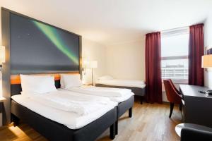 a hotel room with two beds and a window at Scandic Alta in Alta