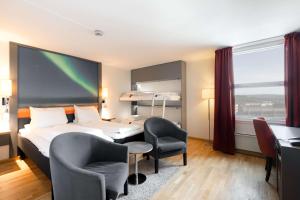 a hotel room with a bed and chairs and a desk at Scandic Alta in Alta