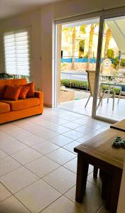 a living room with an orange couch on a tile floor at Peyia Spring in Peyia