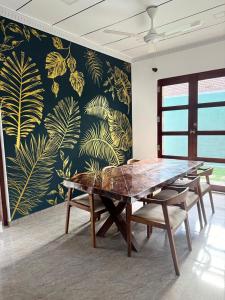 a dining room with a table and chairs and a wallpaper at Villa La Mama Beruwala in Beruwala