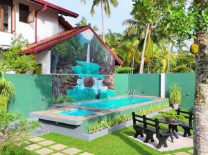 a house with a swimming pool in a yard at Villa La Mama Beruwala in Beruwala