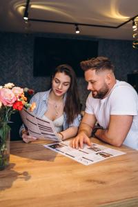 two people sitting at a table looking at a newspaper at Mielno Hotel Boutique in Mielno +191 photos