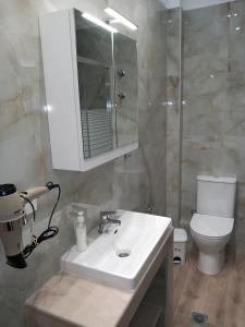 a bathroom with a sink and a toilet and a mirror at Thalassoudis-House 2 in Agios Nikolaos +48 photos