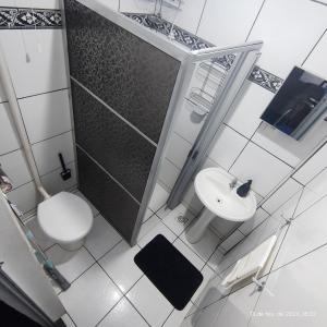 a bathroom with a shower and a toilet and a sink at Casa no Centro, 3 Camas, Garagem, com Netflix e Amazon Prime in Rio das Flores