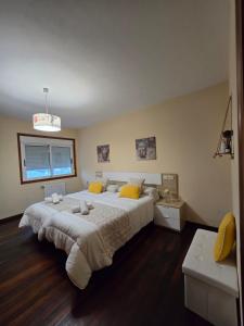 a large bedroom with a large bed with yellow pillows at O Parrandeiro in Padrón