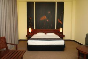 a bedroom with a bed and a painting on the wall at Samudra Training Hotel in Kollupitiya +11 photos