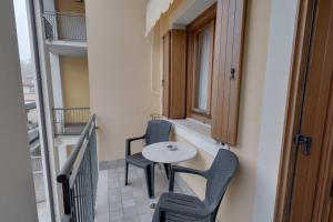 a small balcony with a table and two chairs at Katjas Flower Valley - 2 parcheggi e 2 terrazze in Gorizia