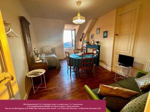 a living room with a table and a couch at Le Chant des Sources, Gîtes et Chambres d'hôtes avec Vue, à Gimel-les-Cascades in Gimel