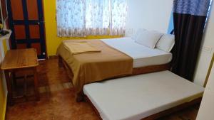 a small room with two beds and a table at Mabla House in Gokarna