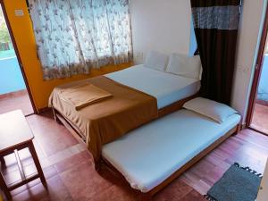 a bedroom with two beds and a window at Mabla House in Gokarna
