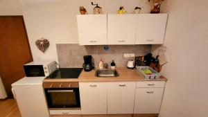 a small kitchen with a sink and a microwave at APARTMA ANTON in Bled +16 photos