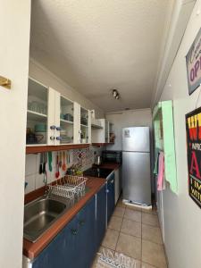 a kitchen with blue cabinets and a stainless steel refrigerator at Cómodo departamento en Curicó in Curicó +3 photos