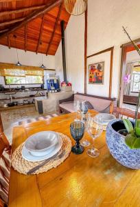 a wooden table with plates and wine glasses on it at Pousada Santa Vila in Serra do Cipo