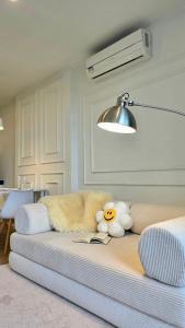 a couch with two stuffed animals on top of it at i-CONDO B2072 in Ban Liap