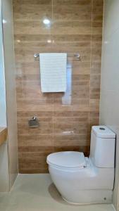 a bathroom with a white toilet and wooden walls at i-CONDO B2072 in Ban Liap +6 photos