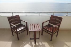 two chairs and a table on a balcony with the ocean at Samudra Training Hotel in Kollupitiya