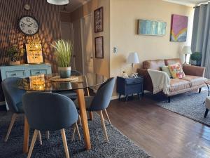 a living room with a table and chairs and a couch at Cómodo departamento en Curicó in Curicó